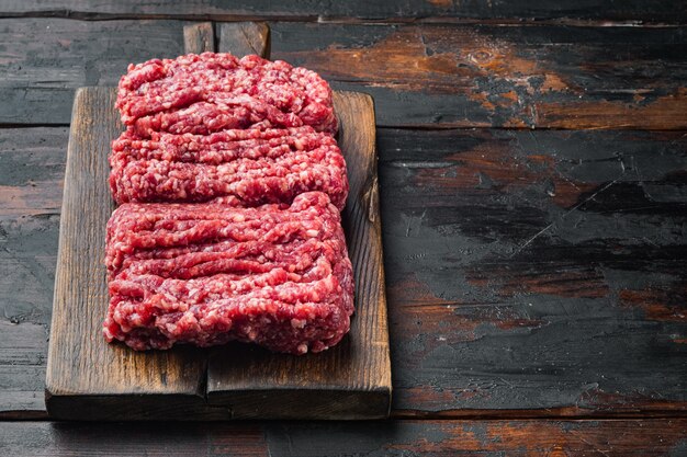 Organic Raw Grass Fed, Ground Beef, on old dark  wooden table background  with copy space for text