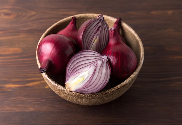 Organic red onions on a wooden background, fresh raw vegetables.