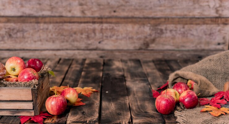 Organic ripe red apples in wooden box. Fall harvest cornucopia in autumn season.