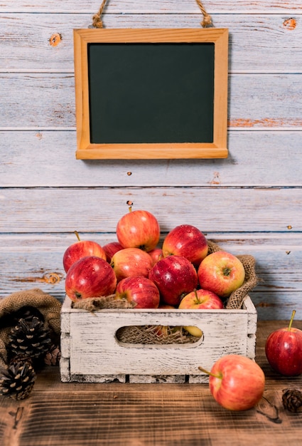 Organic ripe red apples in wooden box. Fall harvest cornucopia in autumn season.