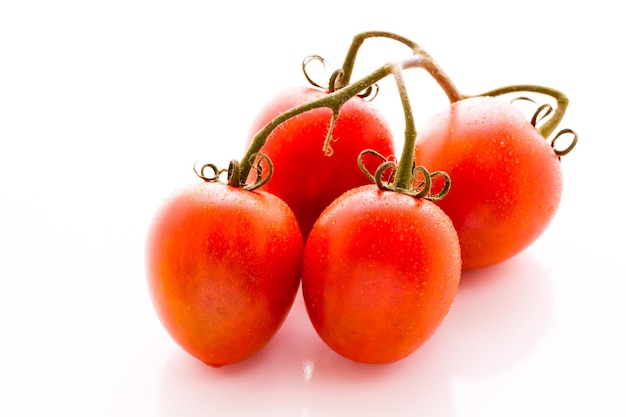 Organic Roma tomatoes on white background.