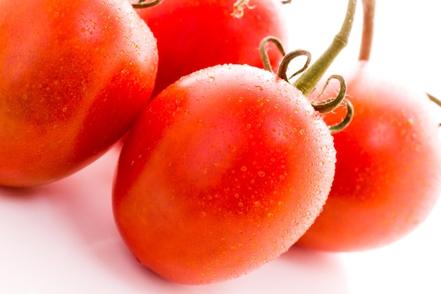 Organic Roma tomatoes on white background.