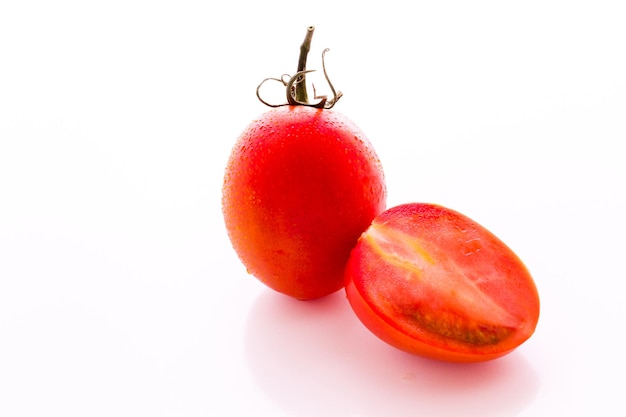 Organic Roma tomatoes on white background.