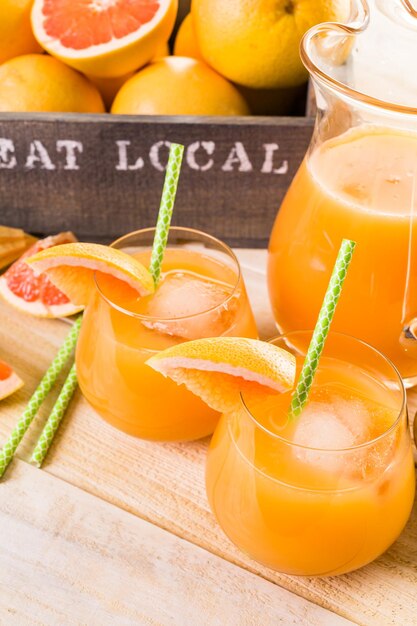 Organic ruby red grapefruit juice in small glass with ice.