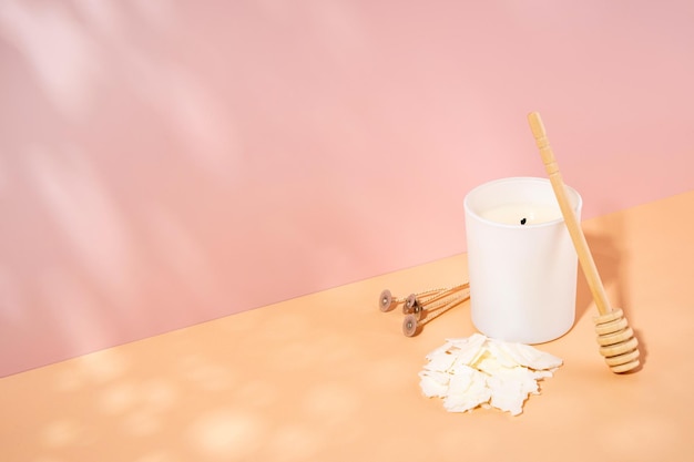 Organic scented soy wax candle wick in a white ceramic jar on a beige pink background Trendy diy handmade concept minimalism isometric projection copy space Horizontal