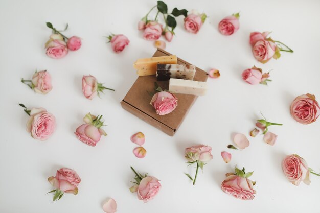 organic soap bars in a craft gift box with flowers on a floral surface top view