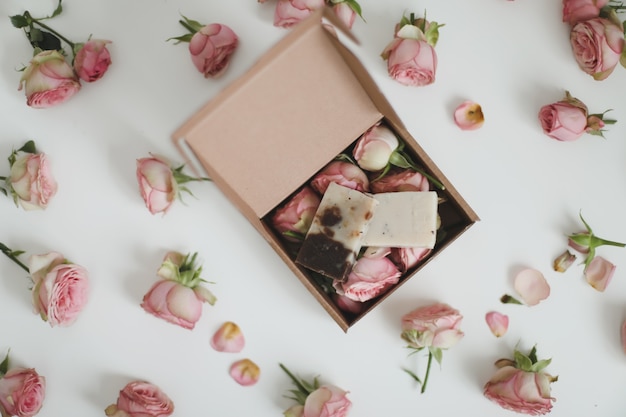 organic soap bars in a craft gift box with flowers on a floral surface top view