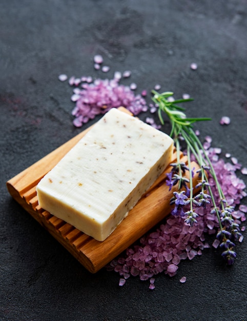 Sapone biologico e un bouquet di fiori di lavanda fresca su sfondo scuro di cemento