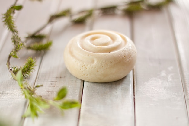 Photo organic soap and the tree leaves on the wooden grey table