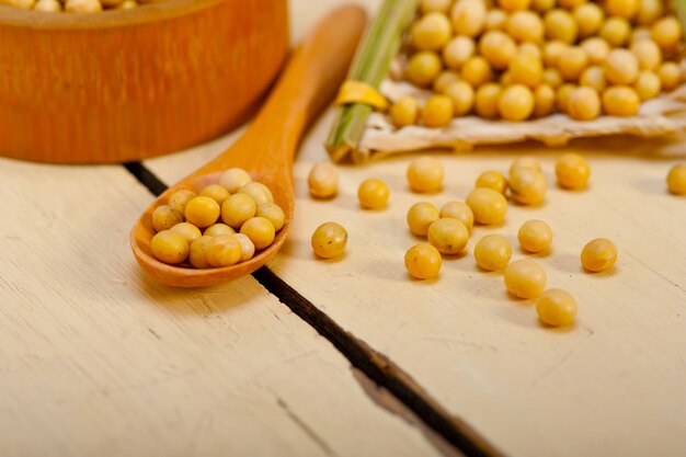 Photo organic soya beans over rustic wood table macro closeup