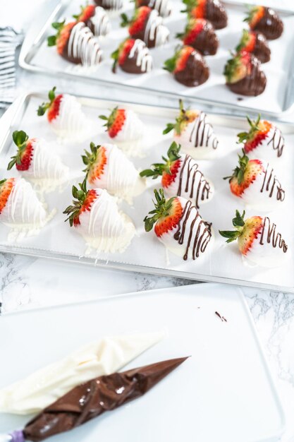 Organic strawberries dipped in chocolate drying on a parchment paper.