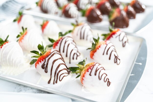 Organic strawberries dipped in chocolate drying on a parchment paper