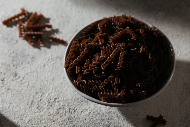 Organic uncooked Buckwheat Fusilli pasta on a grey stone