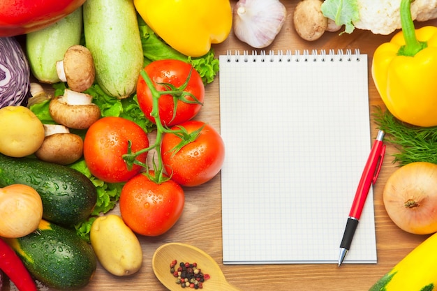 Organic Vegetables on Wooden Background and Notebook