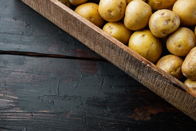 Organic White Baby Potatoes set, in wooden box, on old dark wooden table