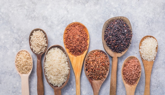 Organic white Jasmine rice, unpolished black and brown rice, Riceberry  in wooden spoons