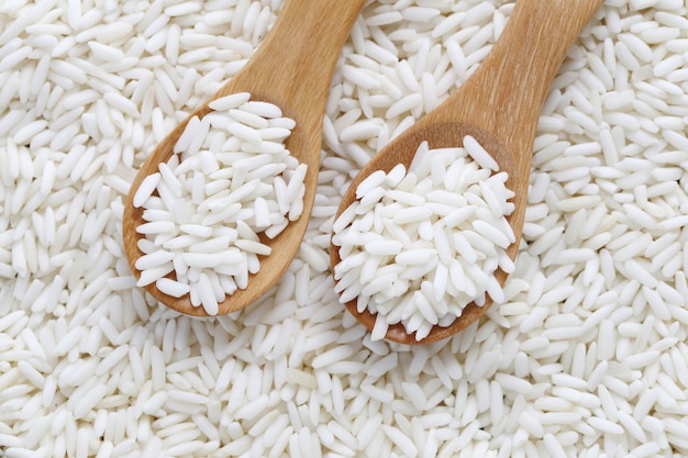 Organic white rice in wooden spoon, glutinous rice or sticky rice.