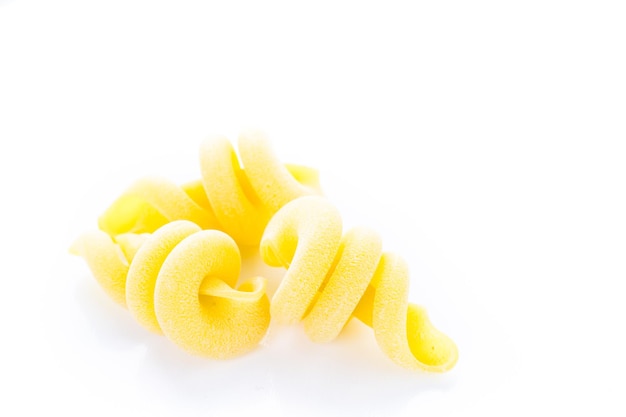 Organic yellow Italian trottole pasta on a white background.