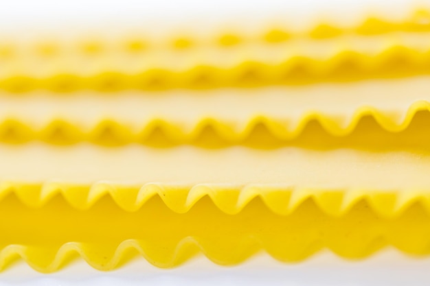 Organic yellow lasagne pasta on a white background