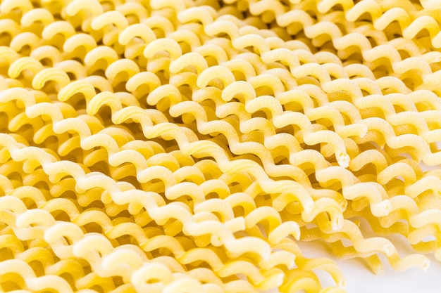 Foto pasta gialla biologica su sfondo bianco.