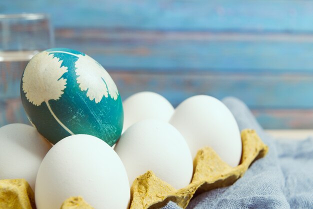 organisch blauw paasei die zich op witte kleureneieren bevinden wacht op het schilderen