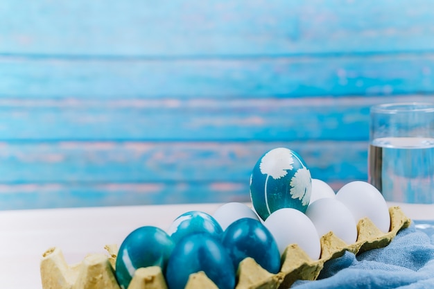 organisch blauw paasei die zich op witte kleureneieren bevinden wacht op het schilderen