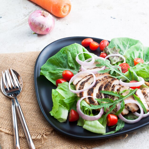 Organische groentesalade met geroosterde kip op zwarte plaat. Gezond eten. Schoonheid concept