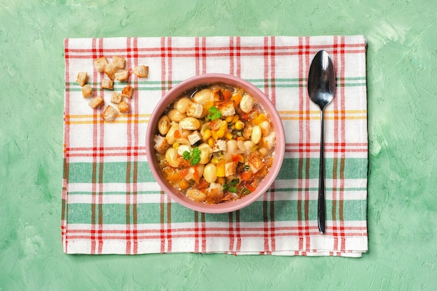 Organische soepsuccotash van de boterbonen, tomaten en likdoorns sluiten omhoog in een kom op de tafel.