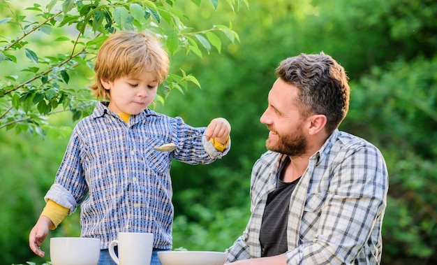 Organische voeding Gezonde voedingsconcept Voedingsgewoontes Familie geniet van zelfgemaakte maaltijden Persoonlijk voorbeeld Voeding kinderen en volwassenen Vader leert zoon natuurlijk eten Kleine jongen en vader eten