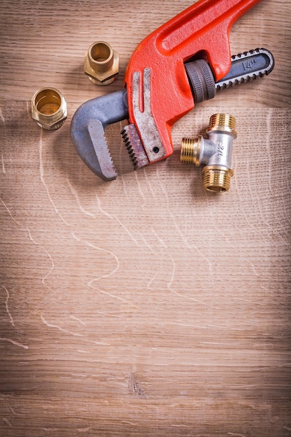 Organized Copysoace Monkey Wrench And Brass Pipe Connectors On Wooden Board