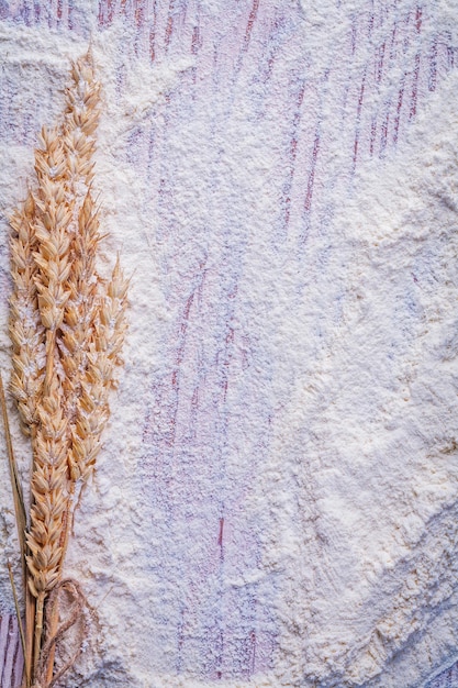 Organized copyspace bunch of wheat ears and flour on vintage wooden board food and drink concept