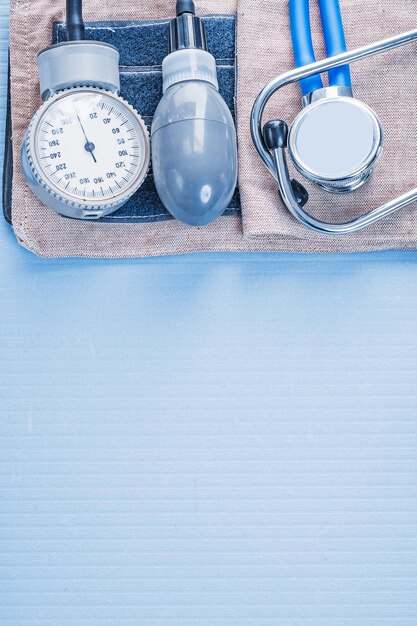 Organized copyspace stethoscope with blood pressure monitor on blue background medical concept