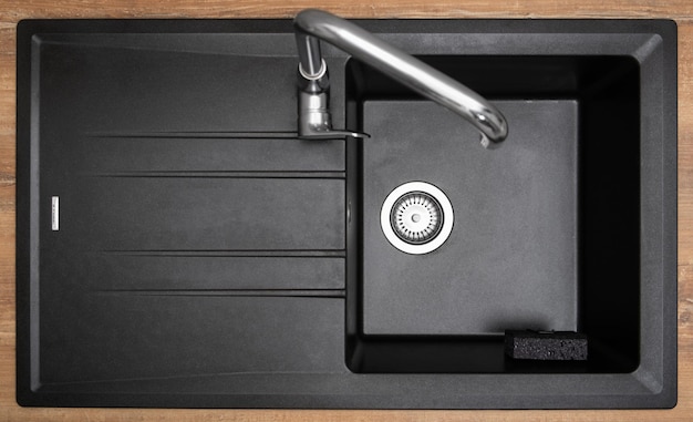 Organizer holder for a kitchen sponge in a black granite sink Storage and organization of space