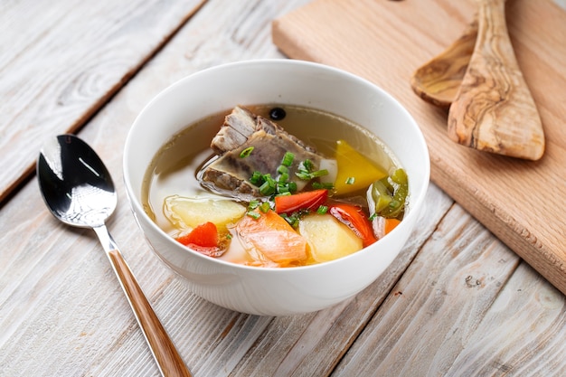 Oriental cuisine shorpa soup with lamb and vegetables in a white bowl