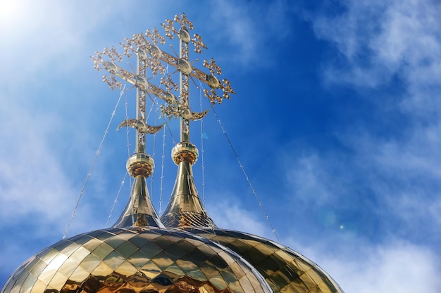 Oriental Orthodox crosses on golden domes of temple against blue sky with clouds Trinity Cathedral of Raifa Monastery Tatarstan Russia