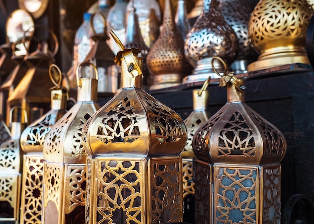 Oriental pattern brass candle lamps on display at souk - traditional street market in Morocco, closeup detail