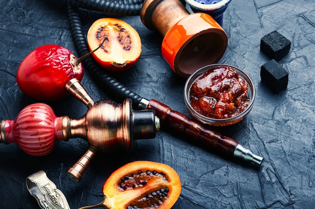 Photo oriental smoking hookah with tamarillo
