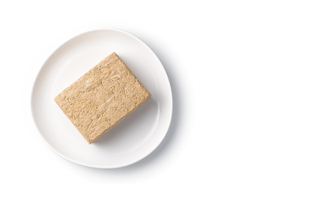 Oriental sweets, halva on a white plate. Top view, isolated object.