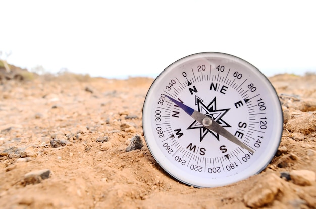 Концепция ориентации Металлический компас на скале в пустыне