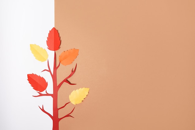 흰색과 갈색 배경에 떨어지는 잎이 있는 종이접기 가을 종이 나무, 복사 공간
