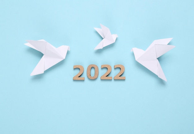 Origami doves and 2022 on blue background Peace symbol