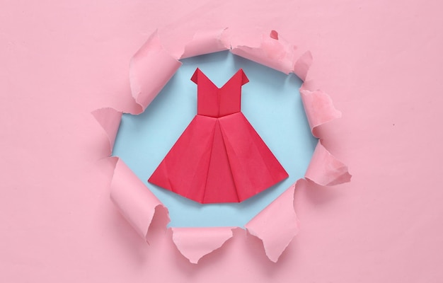 ブルーピンクのパステル背景に引き裂かれた穴から折り紙のドレス コンセプト アート パステル カラーのトレンド ミニマリズム