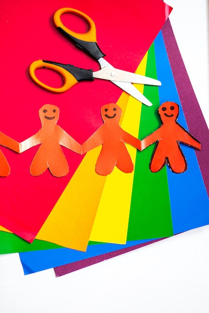 origami in the form of men holding hands on a background of multicolored paper