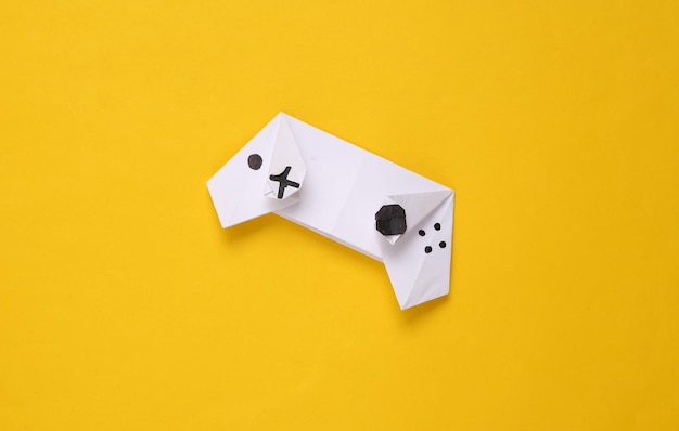 Origami gamepad on yellow background