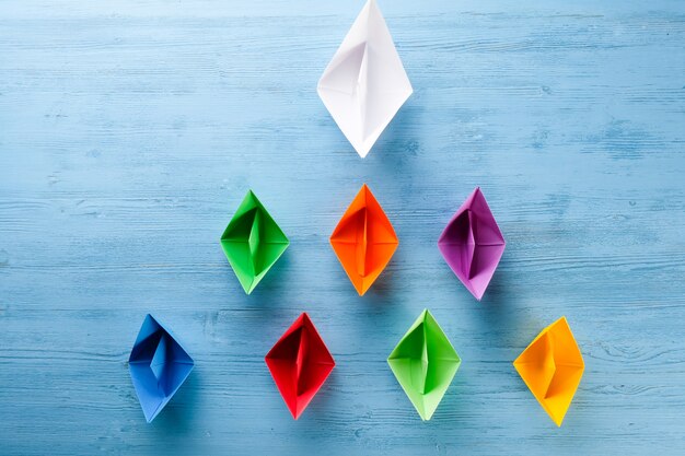 Origami paper boats on a blue table