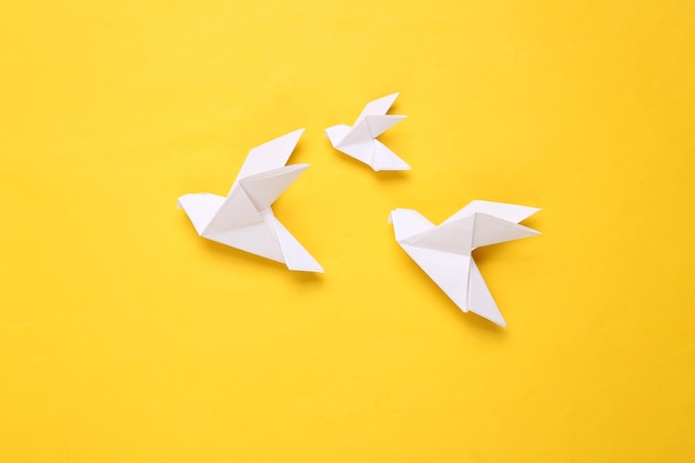 Бумажные голуби оригами на желтом фоне символ мира