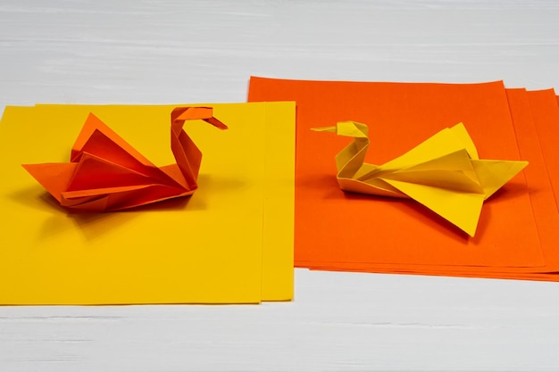 Origami Paper orange and yellow swans on a white background A meeting Side view Creature