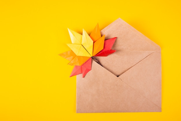 Origami papercraft herfst concept gevallen bladeren brief in een envelop op een effen handgemaakte handgemaakte kunst als achtergrond