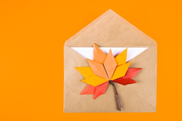 Origami papercraft herfst concept gevallen bladeren brief in een envelop op een gewoon oppervlak ambachtelijke kunst