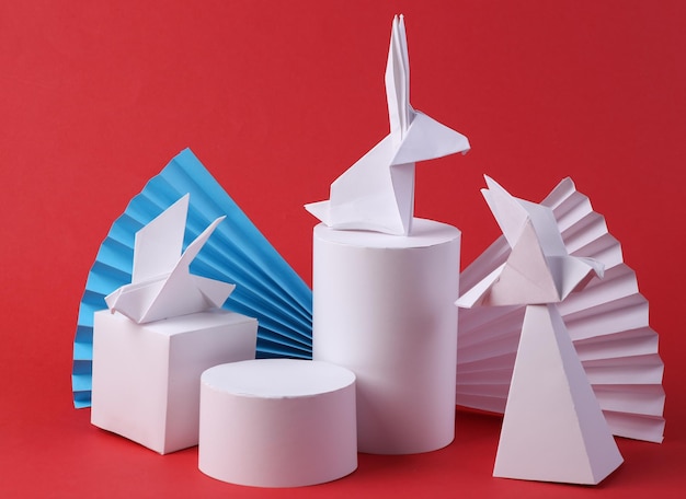 Origami rabbit and birds with geometric shapes on red background Concept art